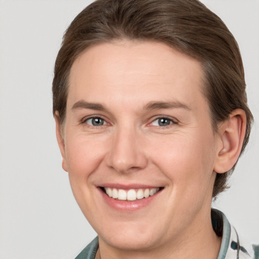 Joyful white young-adult female with short  brown hair and grey eyes