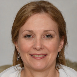 Joyful white adult female with medium  brown hair and blue eyes