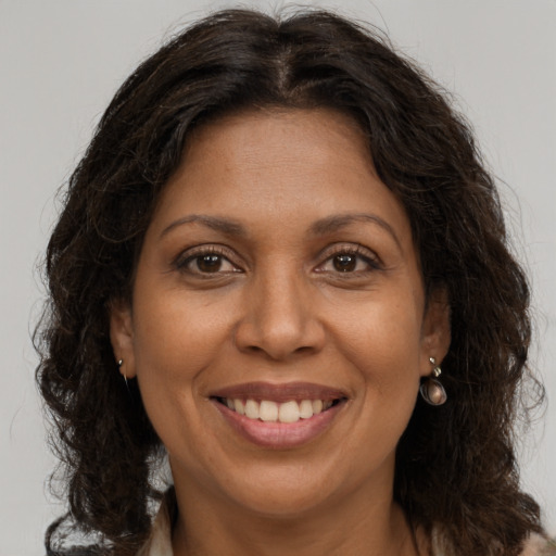 Joyful black adult female with long  brown hair and brown eyes
