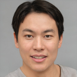 Joyful asian young-adult male with short  brown hair and brown eyes