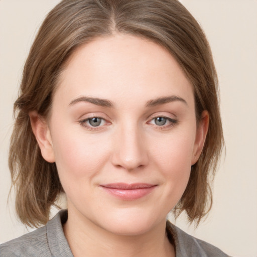 Joyful white young-adult female with medium  brown hair and grey eyes