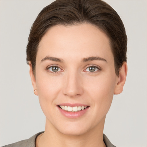 Joyful white young-adult female with short  brown hair and grey eyes