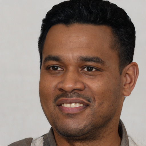 Joyful black young-adult male with short  black hair and brown eyes