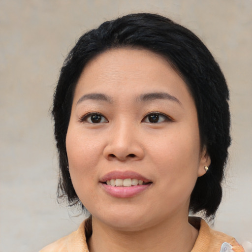 Joyful asian young-adult female with medium  black hair and brown eyes