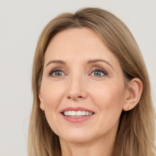 Joyful white adult female with long  brown hair and grey eyes