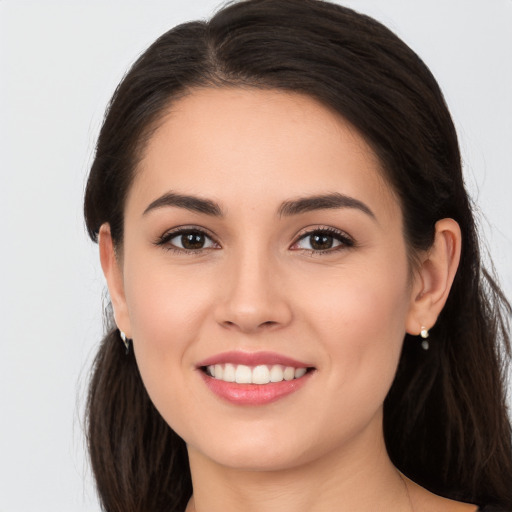 Joyful white young-adult female with long  brown hair and brown eyes