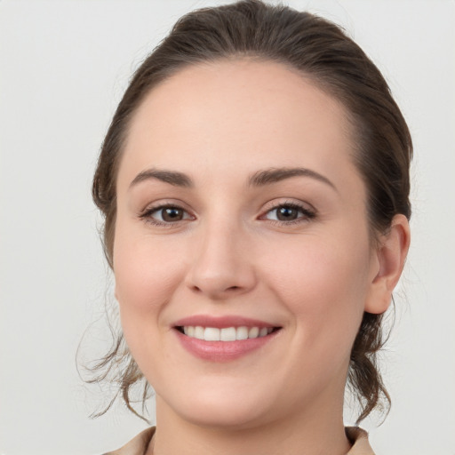 Joyful white young-adult female with medium  brown hair and grey eyes