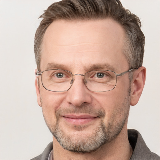 Joyful white adult male with short  brown hair and grey eyes