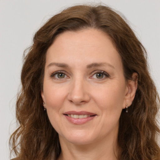 Joyful white adult female with long  brown hair and green eyes