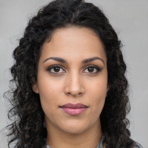 Joyful latino young-adult female with long  brown hair and brown eyes