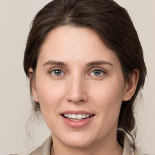 Joyful white young-adult female with medium  brown hair and grey eyes