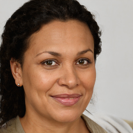 Joyful latino adult female with medium  brown hair and brown eyes