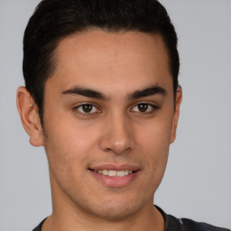 Joyful latino young-adult male with short  brown hair and brown eyes