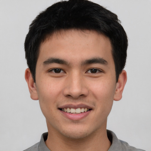 Joyful asian young-adult male with short  brown hair and brown eyes