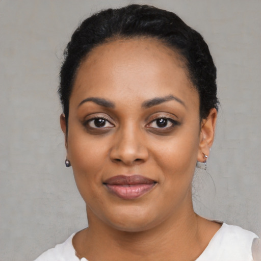 Joyful black young-adult female with short  black hair and brown eyes