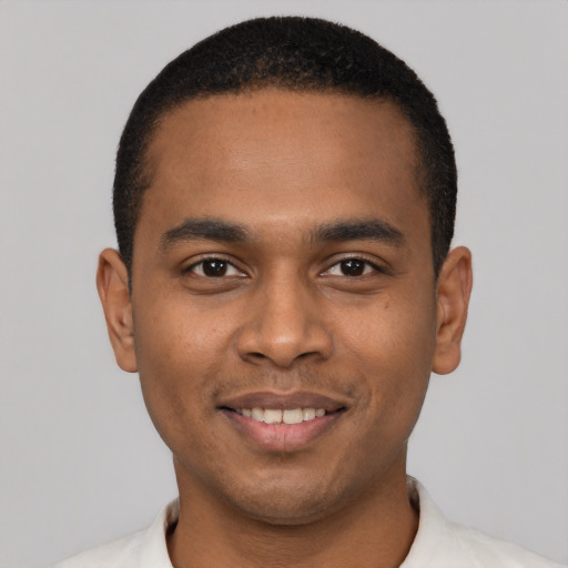 Joyful black young-adult male with short  black hair and brown eyes