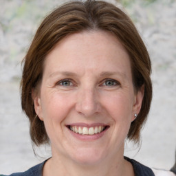 Joyful white adult female with medium  brown hair and grey eyes