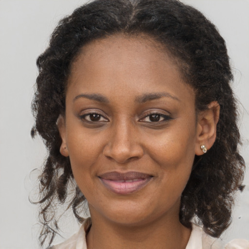 Joyful black adult female with medium  brown hair and brown eyes