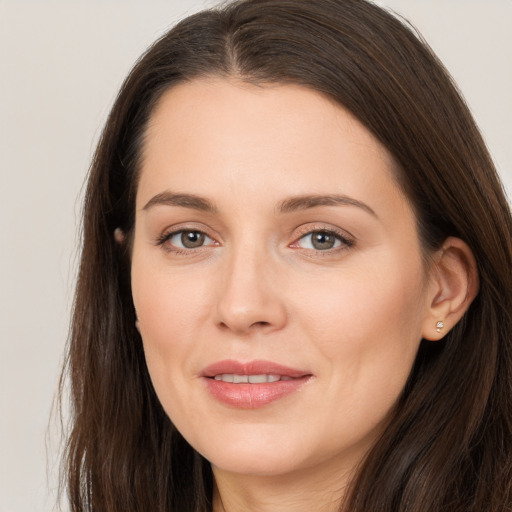 Joyful white young-adult female with long  brown hair and brown eyes