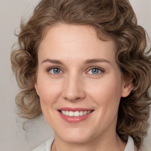 Joyful white young-adult female with medium  brown hair and green eyes