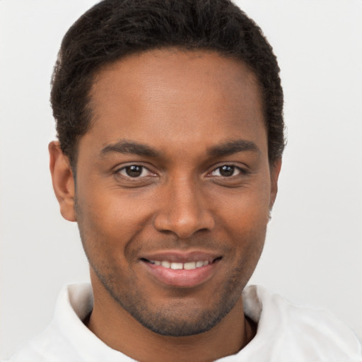 Joyful black young-adult male with short  brown hair and brown eyes