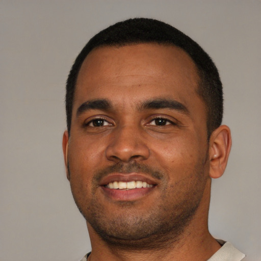 Joyful black young-adult male with short  black hair and brown eyes