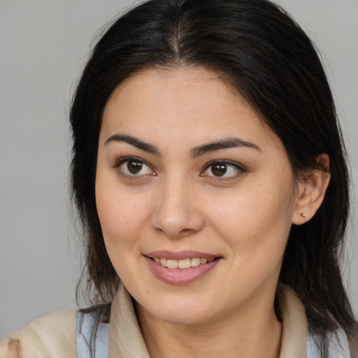 Joyful latino young-adult female with long  brown hair and brown eyes