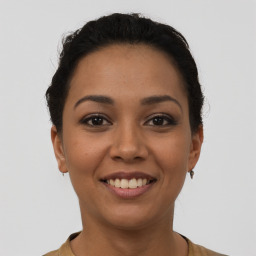 Joyful latino young-adult female with short  black hair and brown eyes