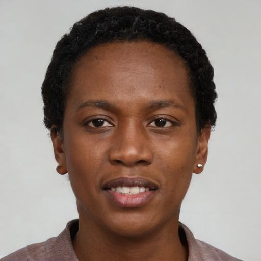 Joyful black young-adult female with short  black hair and brown eyes