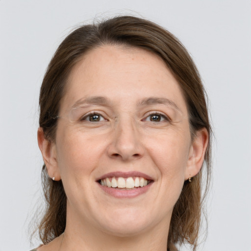 Joyful white adult female with medium  brown hair and grey eyes