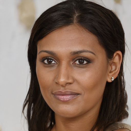 Joyful black young-adult female with long  brown hair and brown eyes