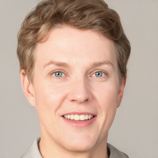 Joyful white adult male with short  brown hair and grey eyes