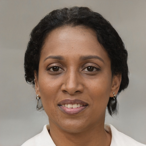 Joyful black adult female with medium  brown hair and brown eyes