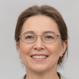 Joyful white adult female with medium  brown hair and grey eyes