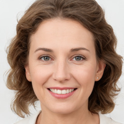 Joyful white young-adult female with medium  brown hair and green eyes