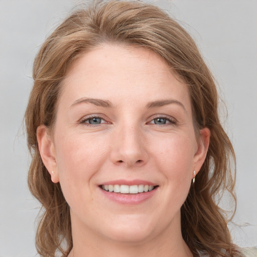 Joyful white young-adult female with long  brown hair and grey eyes