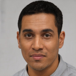 Joyful latino young-adult male with short  black hair and brown eyes