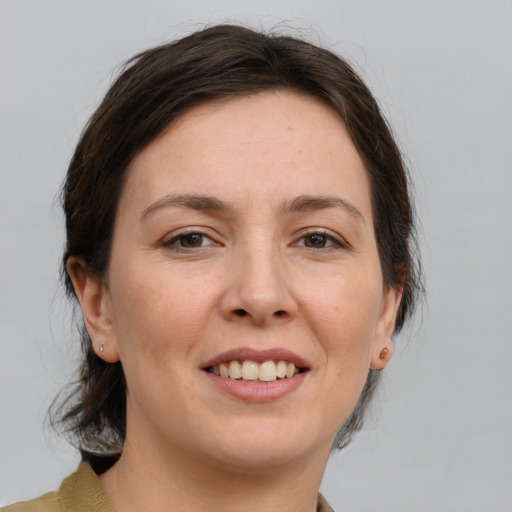 Joyful white adult female with medium  brown hair and grey eyes