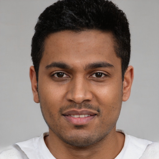 Joyful black young-adult male with short  brown hair and brown eyes