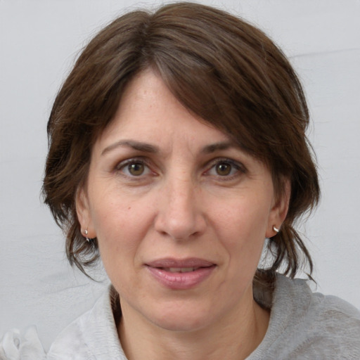 Joyful white adult female with medium  brown hair and grey eyes