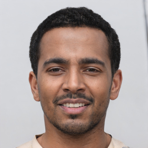 Joyful latino young-adult male with short  black hair and brown eyes