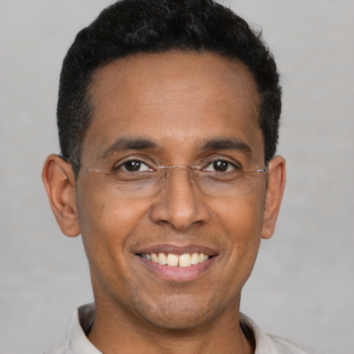 Joyful black adult male with short  black hair and brown eyes