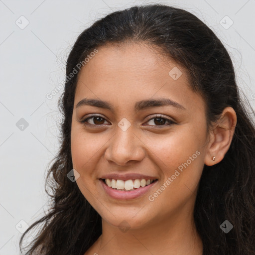 Joyful latino young-adult female with long  brown hair and brown eyes