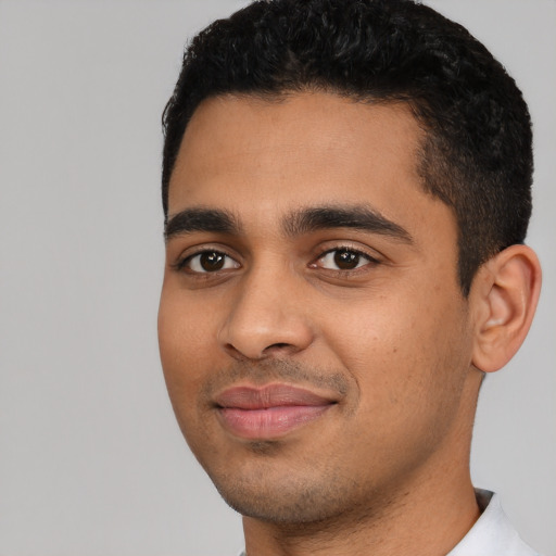 Joyful latino young-adult male with short  black hair and brown eyes