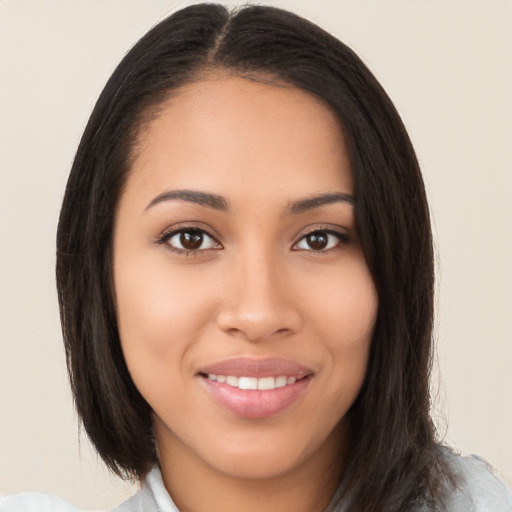 Joyful latino young-adult female with long  brown hair and brown eyes