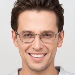 Joyful white young-adult male with short  brown hair and grey eyes