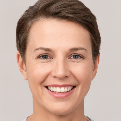 Joyful white young-adult female with short  brown hair and grey eyes