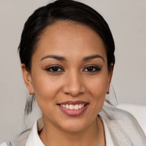 Joyful latino young-adult female with medium  brown hair and brown eyes