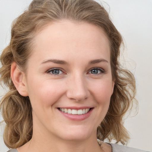 Joyful white young-adult female with medium  brown hair and blue eyes