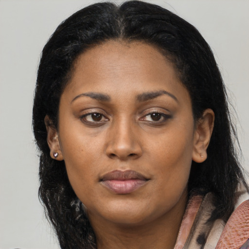 Joyful black young-adult female with long  black hair and brown eyes